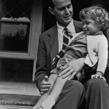 George H.W. Bush sits on porch with his young daughter in his lap