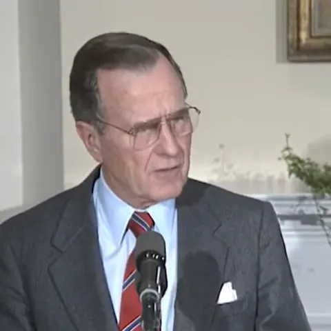 President Bush standing at a podium in the White House while speaking