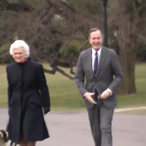The President and First Lady walk outside with their dog. 