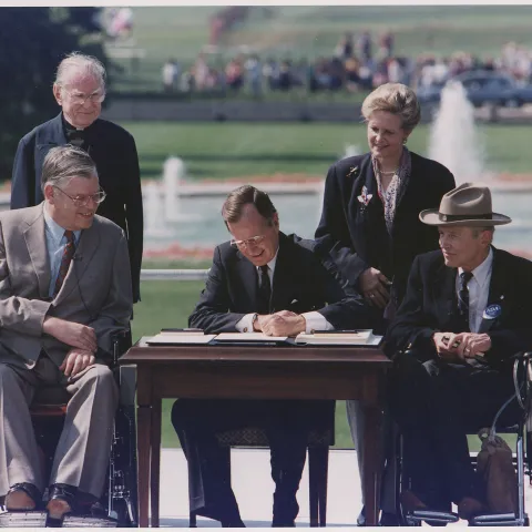 President George Bush signs into law the Americans with Disabilities Act of 1990 on the South Lawn of the White House.