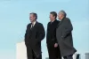 President-Elect Bush, President Reagan, and President Gorbachev stand outside with skyscraper buildings in the background
