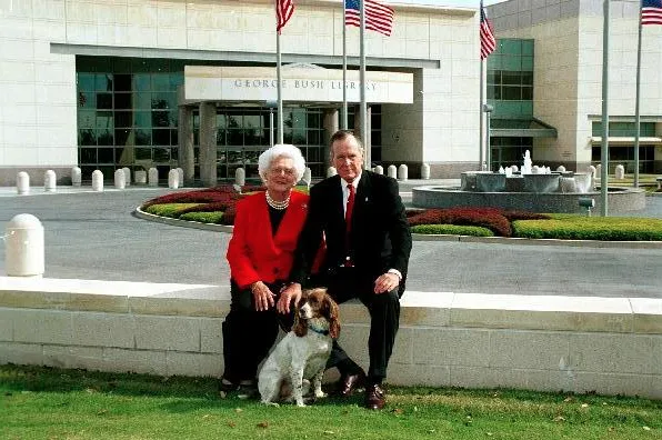 Former President and Mrs. Bush pose in front of the Library for their 2002 Christmas card photo with their dog, Sadie.  08 Nov 02