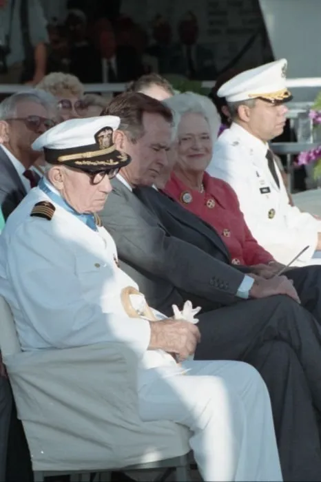 50th anniversary of the Japanese attack on Pearl Harbor, held at the USS Arizona Memorial. Seated with the President are Pearl Harbor Survivor, Captain Donald K. Ross (USN Retired), Mrs. Bush, General Colin Powell, and others.
