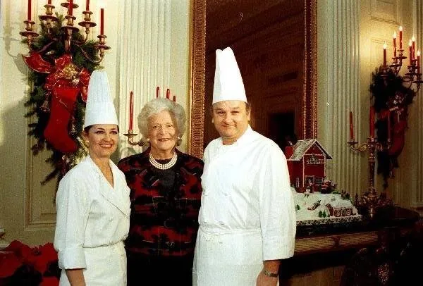 Barbara Bush stands next to gingerbread house with White House Pastry Chef Roland Mesnier