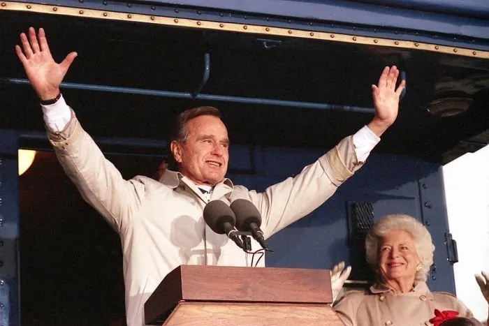 President Bush addresses supporters in Oshkosh, WI as Barbara Bush looks on