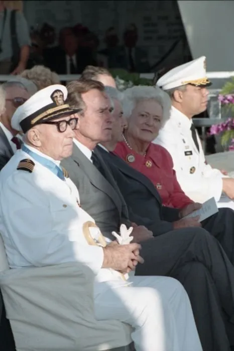 50th anniversary of the Japanese attack on Pearl Harbor, held at the USS Arizona Memorial. Seated with the President are Pearl Harbor Survivor, Captain Donald K. Ross (USN Retired), Mrs. Bush, General Colin Powell, and others.