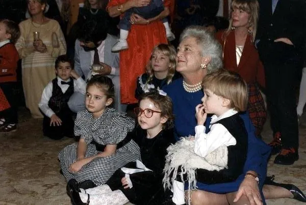 Mrs Bush sits on floor with grandchildren