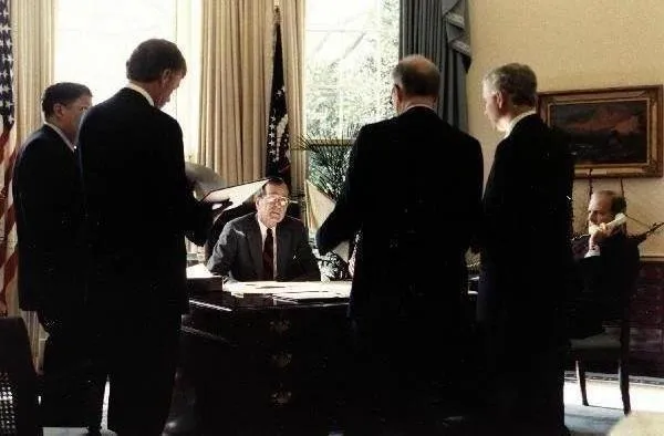 President Bush discusses with staff before announcing 24 hour deadline for Iraq to withdraw