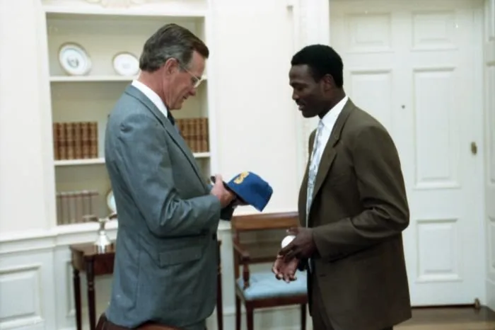 Harold Reynolds presents President Bush with a Seattle Mariners baseball cap
