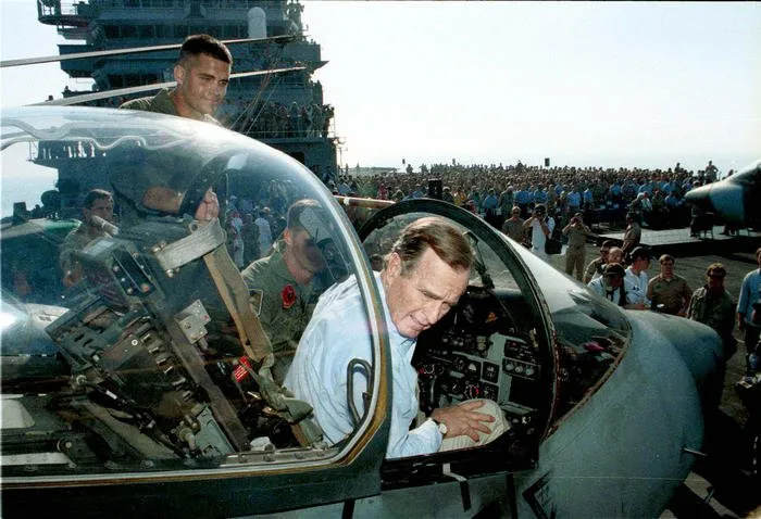 President Bush sits in the cockpit of a plane while visiting service members aboard the USS Nassau in the Persian Gulf.