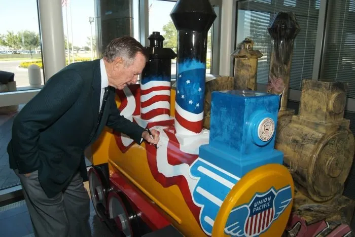 George Bush Signs one of the Miniature Trains Displayed During the "Trains: Tracks of the Iron Horse" Exhibit