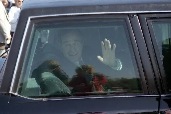 President Bush waves from his limousine