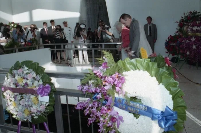 President and Mrs. Bush drop a wreath into the USS Arizona Memorial aft during a ceremony commemorating the 50th anniversary of the Japanese attack on Pearl Harbor.