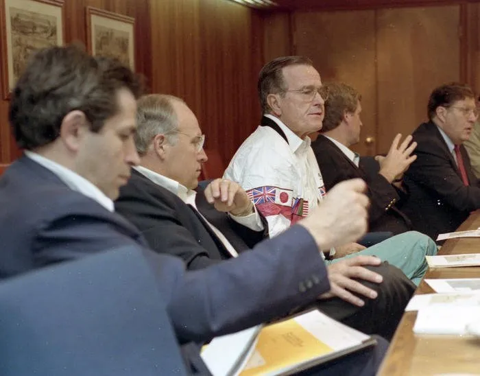 President Bush meets with National Security Advisors regarding Iraq's invasion of Kuwait (l to r: Paul Wolfowitz, Sec. Richard Cheney, President Bush, Vice President Quayle, Gov. John Sununu) at Camp David