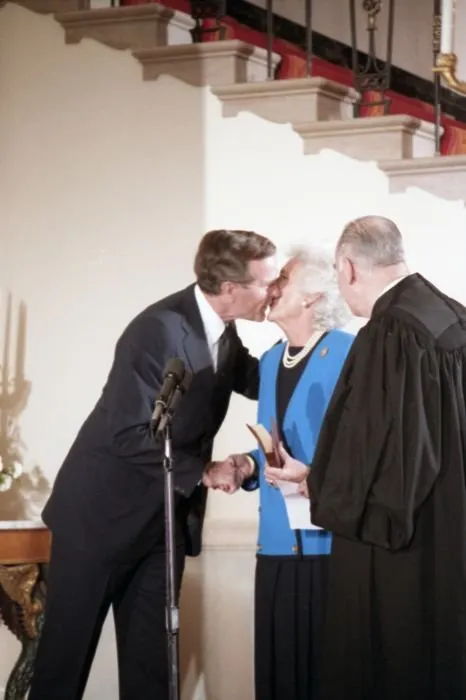 Vice President George Bush gives Mrs. Bush a kiss after having just taken the Vice Presidential Oath of Office at a  private swearing in ceremony at the White House.  Supreme Court Justice Potter Stewart looks on