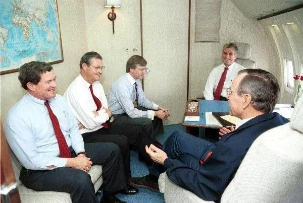President Bush visits with staff aboard Air Force One
