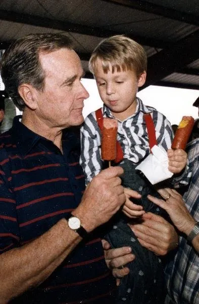 Vice President Bush visits with a young supporter during a campaign reception in Dallas, TX
