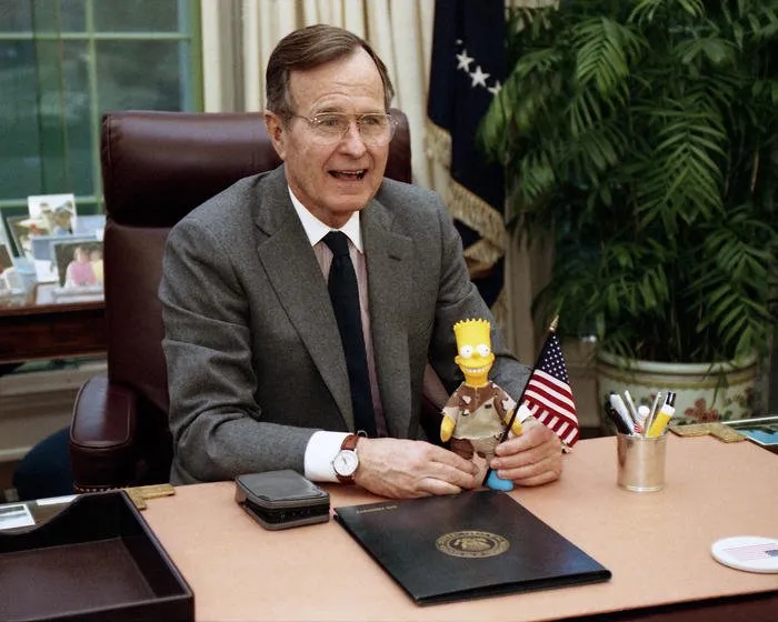 President Bush poses for a photo with a Bart Simpson doll, which troops in Saudi Arabia gave to Secretary Richard Cheney and General Colin Powell to deliver to the President