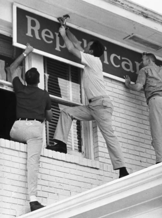 George Bush and his team nail up the Republican headquarters sign