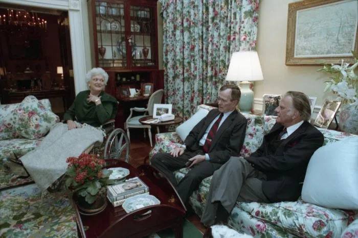 President and Mrs. Bush watch news coverage of Operation Desert Storm with Reverend Billy Graham in the living room of the White House Residence