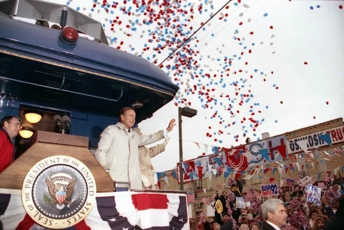 President Bush addresses supporters in Oshkosh, WI as Barbara Bush looks on