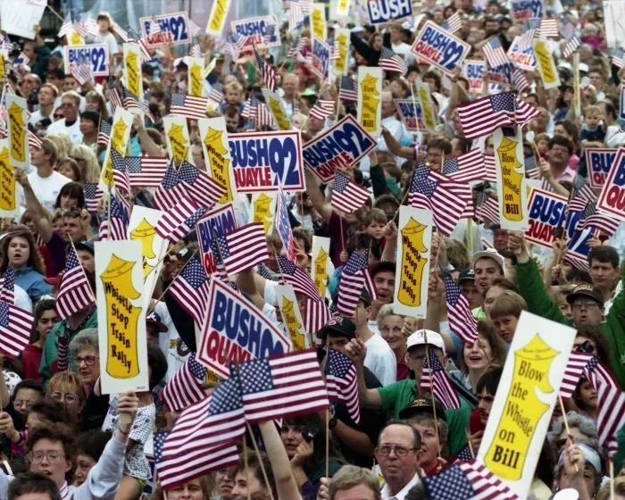 Supporters wave flags and campaign signs during an address by President Bush in Bowling Green, OH