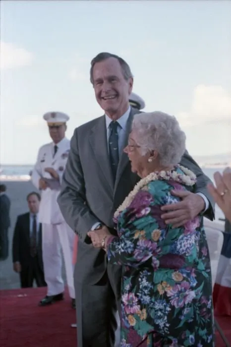 President Bush greets Mrs. Lenore Rickert, retired Navy nurse and survivor of the Japanese attack on Pearl Harbor, on stage at Pearl Harbor Naval Base Kilo 8 Pier during a ceremony commemorating the 50th anniversary of the attack.