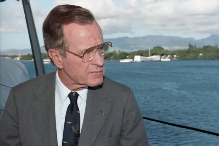 President Bush participates in a television taping session aboard the USS Missouri on the 50th anniversary of the Japanese attack on Pearl Harbor. The USS Arizona Memorial is visible in the background