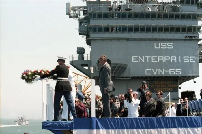 Vice President Bush looks on as a sailor and a marine as they prepare to throw a wreath from the USS Enterprise in San Francisco Bay during the "Peace in the Pacific" ceremony marking the 40th Anniversary of VJ Day