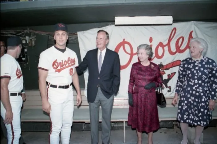 President Bush,  Barbara Bush,  and Queen Elizabeth II take a photo with Cal Ripken, Jr in Baltimore Orioles dugout