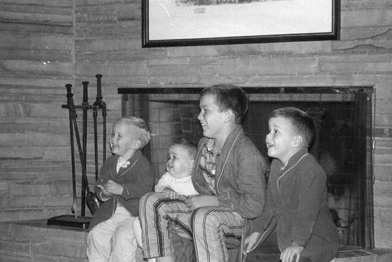 Neil, Marvin, George W. and Jeb Bush sitting on a fireplace