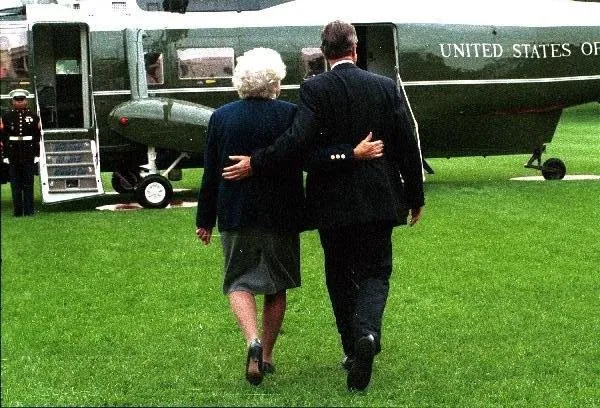 President Bush and Barbara Bush walk arm-in-arm toward Marine One