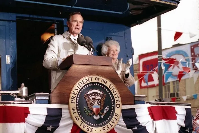 President Bush addresses supporters in Oshkosh, WI as Barbara Bush looks on