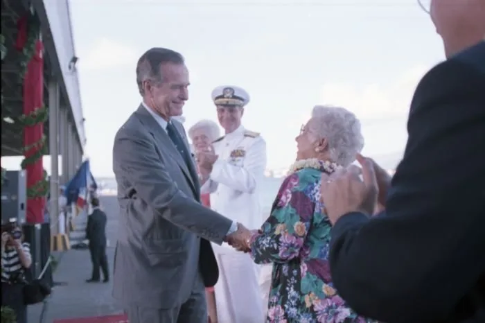 President Bush greets Mrs. Lenore Rickert, retired Navy nurse and survivor of the Japanese attack on Pearl Harbor, on stage at Pearl Harbor Naval Base Kilo 8 Pier during a ceremony commemorating the 50th anniversary of the attack.