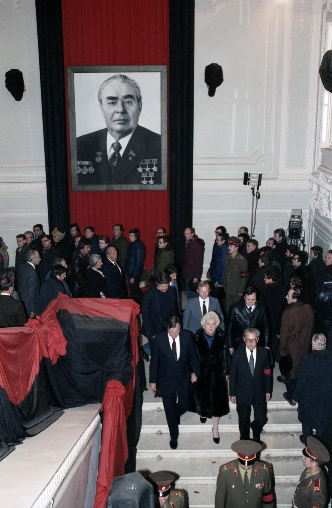 Vice President George Bush, Secretary of State George Shultz, Ambassador to the Soviet Union Arthur Hartman, Barbara Bush and others are escorted down the stairs at the Kremlin Palace after paying their respects at the funeral bier of Soviet leader Leo...