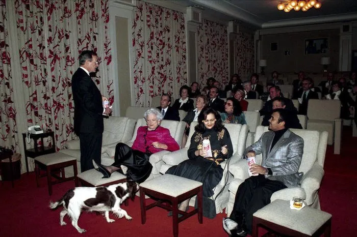 President and Mrs. Bush, accompanied by their dog Millie, host a movie night for Prince Bandar in the White House Theater