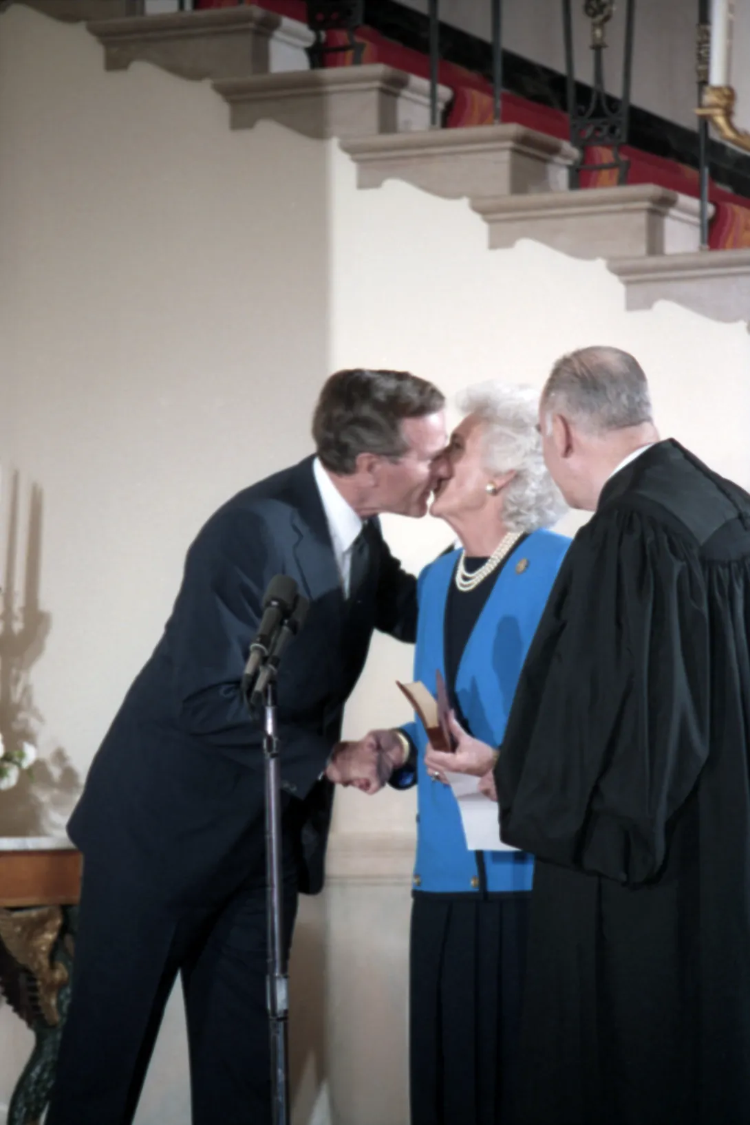 Vice President George Bush gives Mrs. Bush a kiss after having just taken the Vice Presidential Oath of Office at a  private swearing in ceremony at the White House.  Supreme Court Justice Potter Stewart looks on