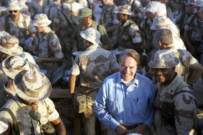 Senator Bob Dole mingles with troops at First Marine Division Command Post in Saudi Arabia during a Thanksgiving visit with the troops on which he and other congressional leaders accompanied the Bushes