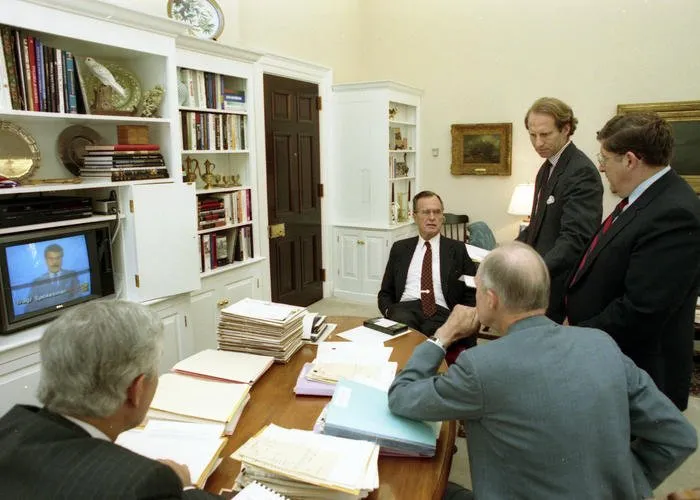 President Bush, Robert Gates, Gen. Scowcroft, Gov. Sununu, and Richard Haass watch an Iraqi spokesman on the television in Gen. Scowcroft's office