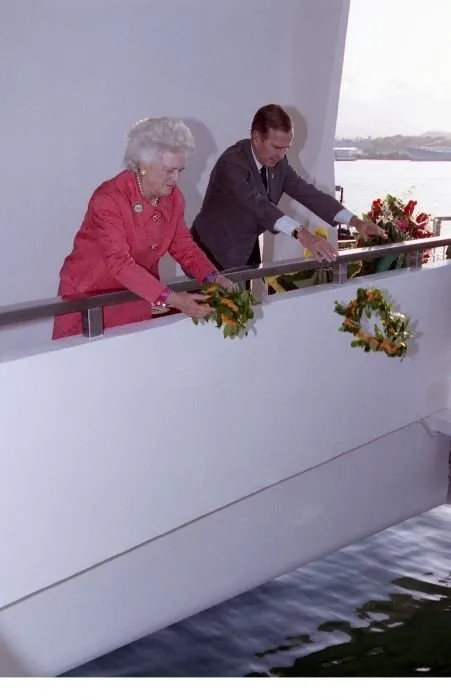 President and Mrs. Bush drop wreaths into the water from the USS Arizona Memorial.