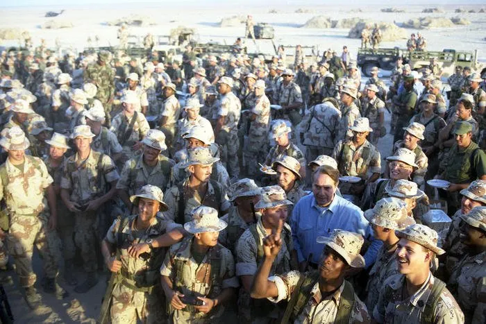 Senator Bob Dole mingles with troops at First Marine Division Command Post in Saudi Arabia during a Thanksgiving visit with the troops on which he and other congressional leaders accompanied the Bushes