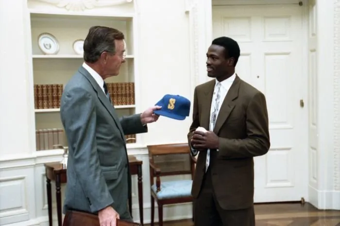 Harold Reynolds presents President Bush with a Seattle Mariners baseball cap