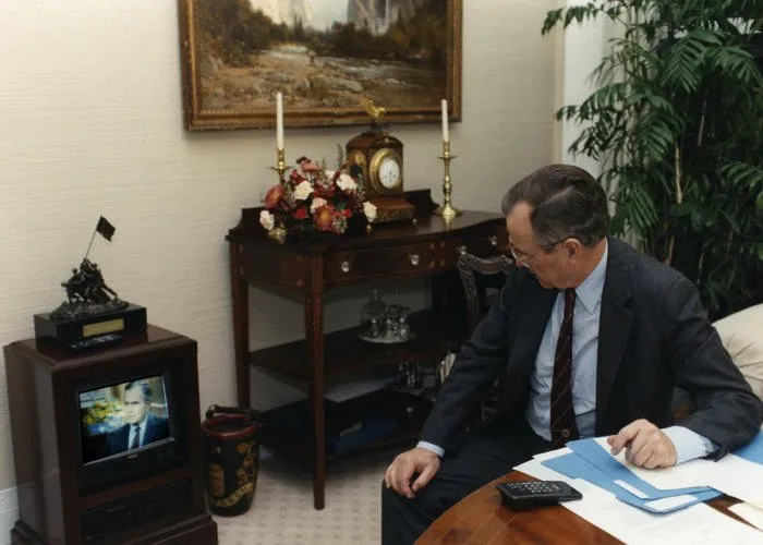 President Bush watches footage of himself on television