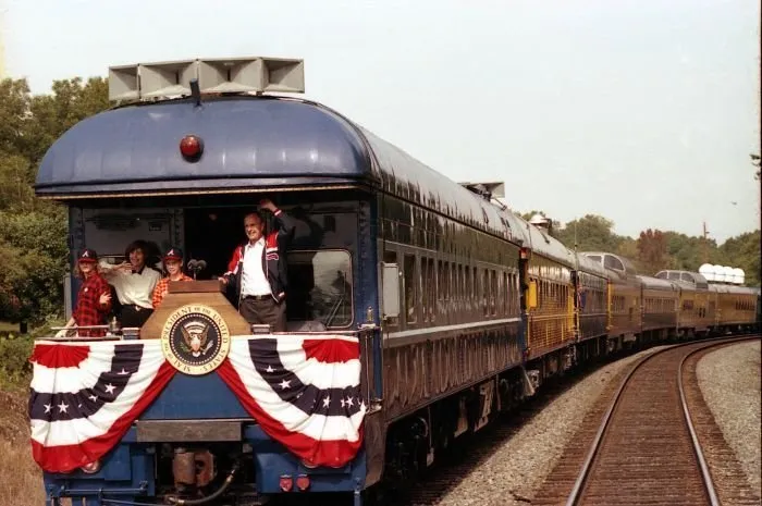 President Bush , Laura, Jenna, and Barbara Bush greet people along the train route from Norcross to Gainesville during the whistle-stop through Georgia