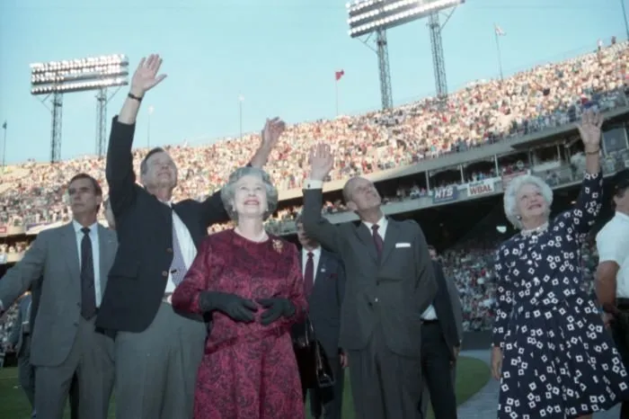 President Bush,  Queen Elizabeth II, Prince Philip, and Barbara Bush wave to the crowd at Memorial Stadium