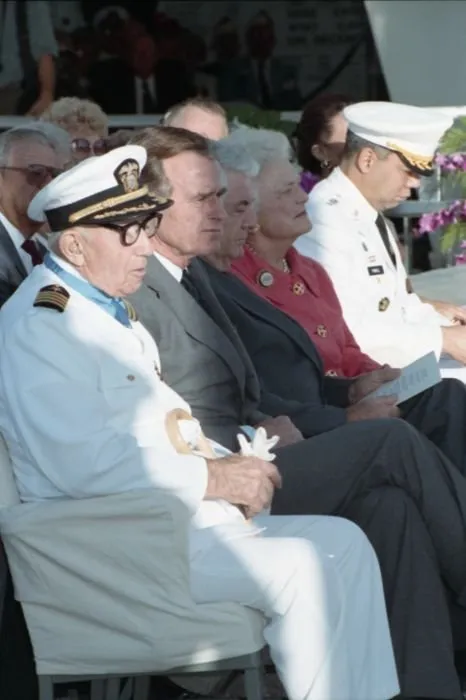 50th anniversary of the Japanese attack on Pearl Harbor, held at the USS Arizona Memorial. Seated with the President are Pearl Harbor Survivor, Captain Donald K. Ross (USN Retired), Mrs. Bush, General Colin Powell, and others.
