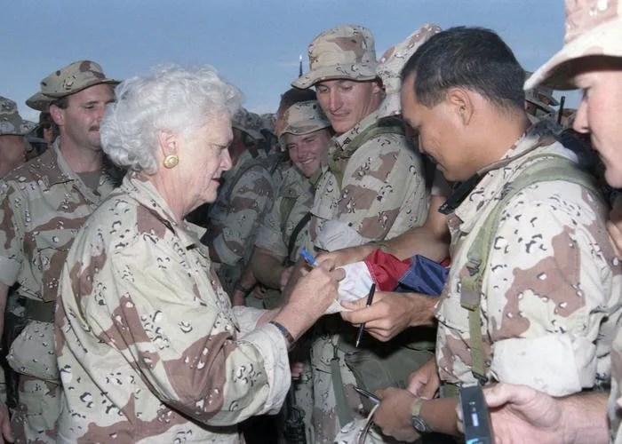 Mrs. Bush signs a flag for one of the troops stationed in Saudi Arabia