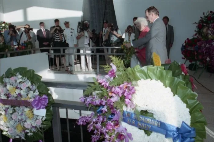 President and Mrs. Bush drop a wreath into the USS Arizona Memorial aft during a ceremony commemorating the 50th anniversary of the Japanese attack on Pearl Harbor.