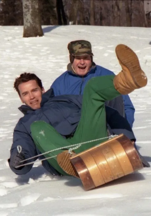 President Bush and Arnold Achwarzenegger sledding at Camp David