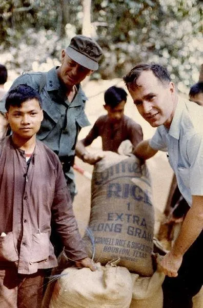 George Bush and Gen. F.K. Means Load Captured Viet Cong Rice